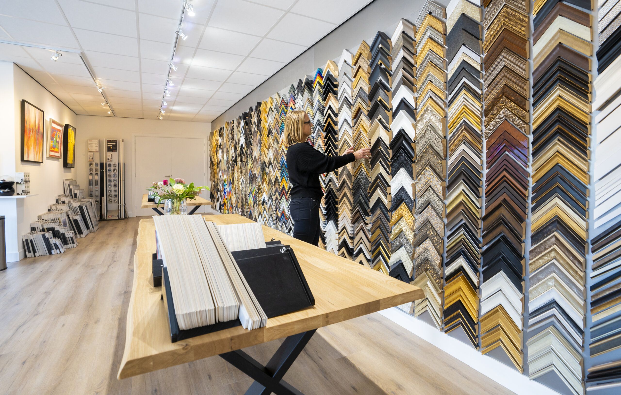 Het atelier van Baspartout met een wand vol frameprofielen
